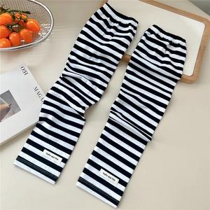 Detail of black and white striped sun protection arm sleeves with a square woven label