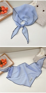 Detail of blue striped chiffon scarf with wavy edges and a nice moment fabric tag