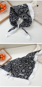 Detail of paisley print silk scarf with delicate white lace trim and soft texture