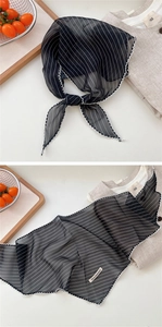 Detail of lightweight black striped neck scarf with delicate white lace trim on soft fabric
