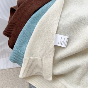 Detail showing 100% pure wool texture and labels of the knitted shawl wrap