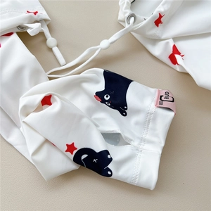 Close-up of white sun sleeves featuring cute cat and red star prints with a toggle cord