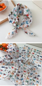 Detailed view of white cotton linen scarf featuring colorful cartoon dog print patterns