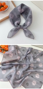 Detail of grey floral cotton linen scarf featuring pink fireworks print tied in a bow