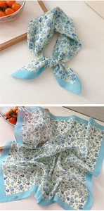 Macro shot of 100% cotton floral scarf in light blue showing texture and knot detail