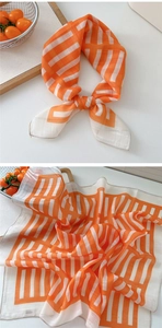 Detail of geometric orange and white striped cotton linen scarf with soft texture