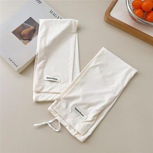 Detail view of cream ribbed knit arm sleeves with drawstring and brand label