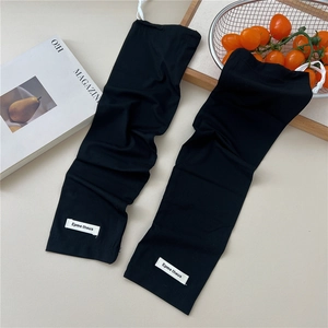 Close-up of black ribbed cooling arm sleeves featuring a white woven label and soft texture