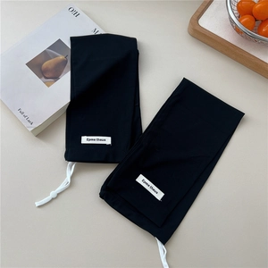 Close-up of black ribbed knit sun sleeves with white drawstring and brand label