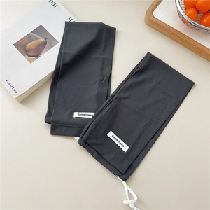 Detailed close-up of dark grey ribbed cooling arm sleeves with white drawstring and brand tag