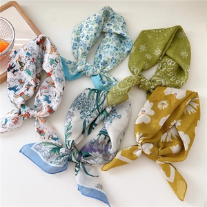 Five assorted cotton linen square neck scarves with floral and paisley prints on white table