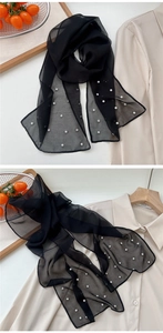 Macro detail of black sheer scarf with white pearls and sparkling rhinestone embellishments