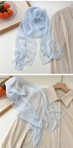 Detail of light blue semi-transparent scarf with white faux pearls and rhinestones