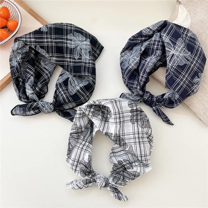 Floral and plaid cotton linen hair scarves in black, navy, and white on a wooden tray