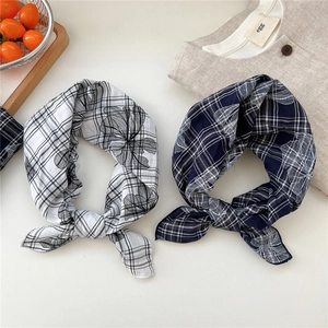 Detail view of cotton linen scarves with floral print and classic plaid pattern