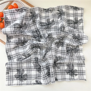 Close-up of black and white checkered floral cotton linen scarf with fine edge stitching