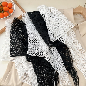 Detail showing intricate floral embroidery and scalloped lace edge on fabric accessory