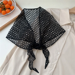 Detail of black lace hollow-out shawl with diamond mesh pattern and delicate tie-up bow