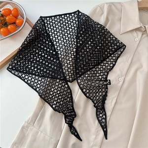 Close-up of black hollow lace triangular scarf with geometric crochet pattern