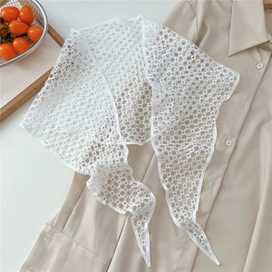 Close-up of white floral lace scarf with intricate hollow out crochet geometric patterns