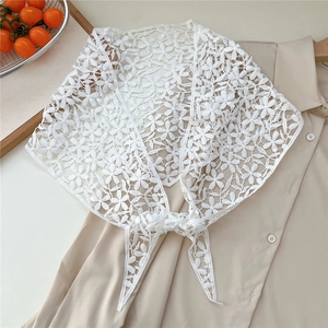 Detailed close-up of white floral lace triangle scarf featuring intricate hollow embroidery