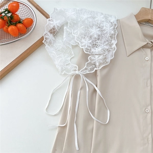 Detailed view of white floral lace waistband with delicate embroidery and wavy edges