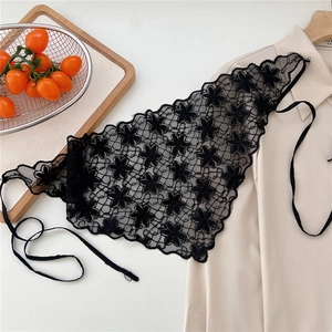 Detail of black floral crochet lace triangle scarf showing intricate petal embroidery