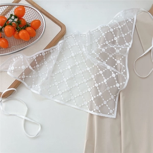 Close-up of white floral lace embroidery with daisy patterns and mesh details