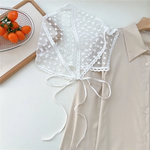 Close-up of white lace triangle scarf featuring heart mesh embroidery and wavy edges