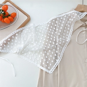 Close-up of white lace waist wrap with heart patterns over a beige shirt