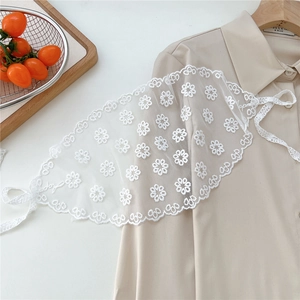 Detailed view of white floral lace collar with delicate embroidery and adjustable ribbons