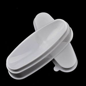 White oval French manicure dip tray tool made of glossy ABS plastic on black background
