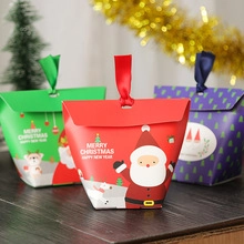 Close-up of festive Christmas gift bags with gold foil lettering and ribbon handles