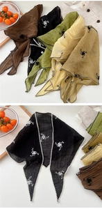 Detail of embroidered floral headscarf with scalloped edges and textured fabric