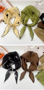 Detail of four embroidered floral triangle scarves with wavy crochet edges and seersucker texture