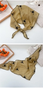 Detail of ginger yellow triangle headscarf with black floral embroidery and scalloped edges