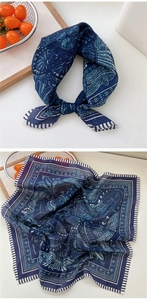 Détail d'un foulard en soie bleu marine avec motif paisley et style de nœud élégant