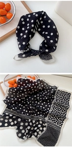 Vue détaillée d'un foulard en soie à pois noirs et blancs avec nœud élégant