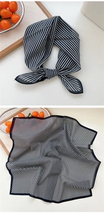Détail d'un foulard carré en soie à rayures noires et blanches avec bordure délicate