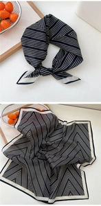 Gros plan d'un foulard en soie rayé noir et blanc avec un nœud élégant