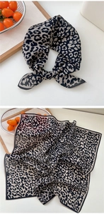 Vue détaillée d'un foulard carré en soie à imprimé léopard plié et plat aux bords raffinés