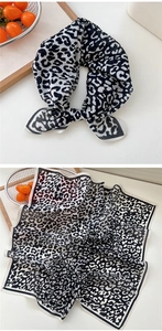 Détail d'un foulard carré en soie présentant un imprimé léopard noir et blanc élégant