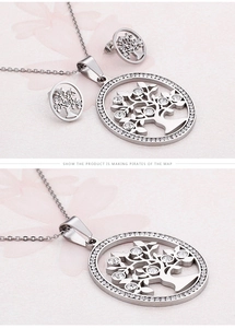 Detailed view of silver tree of life necklace and earrings set with sparkling crystals