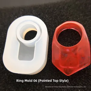 Dettaglio dello stampo in silicone per anello geometrico e anello in resina rossa su sfondo nero