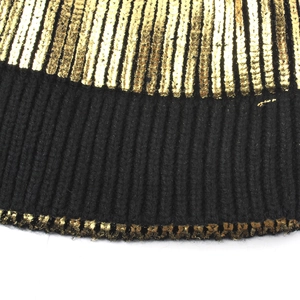 Detailed macro view of the black knit beanie with gold metallic striped texture