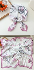 Detail of printed silk scarf featuring cartoon rabbit and purple borders on white fabric