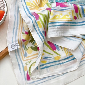 Detailed close-up of printed silk scarf showing colorful summer patterns and stitching