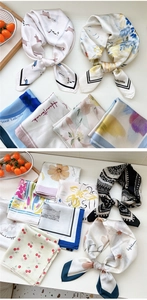 Flat lay detail of colorful printed satin scarves with floral and cartoon patterns