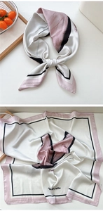 Detail view of a cream and pink silk square scarf featuring artistic butterfly patterns