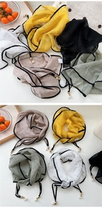 Close-up of lightweight diamond scarves with elegant pearl pendants in multiple colors